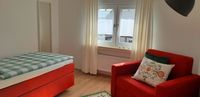 Eifelsch&auml;tzchen_Einzel-Doppelschlafzimmer_Einzelbett orange und Sessel